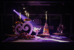 Table de mariage avec pièce montée de choux à la crème et flambeaux.