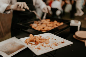 Préparation de crevettes et gambas cuites à la planche pour fête de mariage et réception.