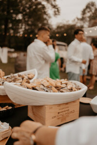 Plateaux de fruits de mer et huitres posés sur caisse de bouteilles de vin. Fête de mariage.