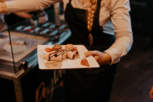 Serveuse préparant assiette de mets amuses-bouche pour festivités de mariage.