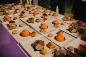 Table composée d'assiettes carrées de desserts pour fête de mariage.