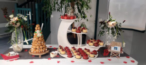 Table avec préparations sucrées, pièce montée de choux, petits gâteaux et décorée d'objets sur thème de la mer