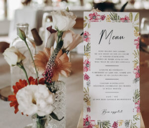 table décorée avec menu posé sur la nappe et fleurs